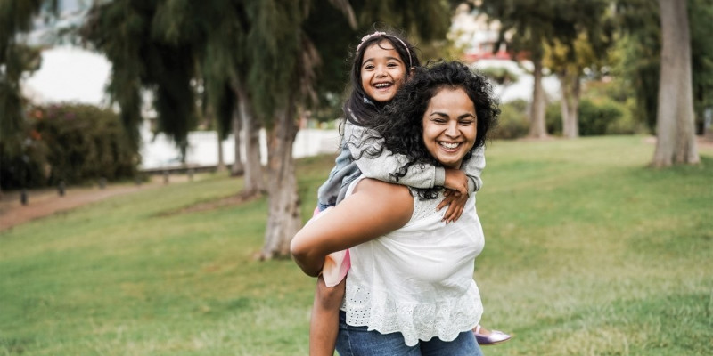 A Mum and her daughter playing in a park.