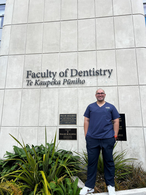 Full body shot of Mani standing in front of Faculty of Dentistry building